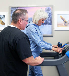 therapist helping patient on treadmill