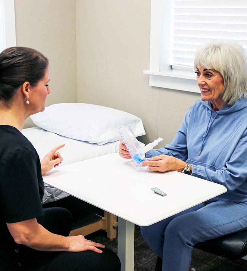 Physical therapist helping patient with pulmonary physical therapy