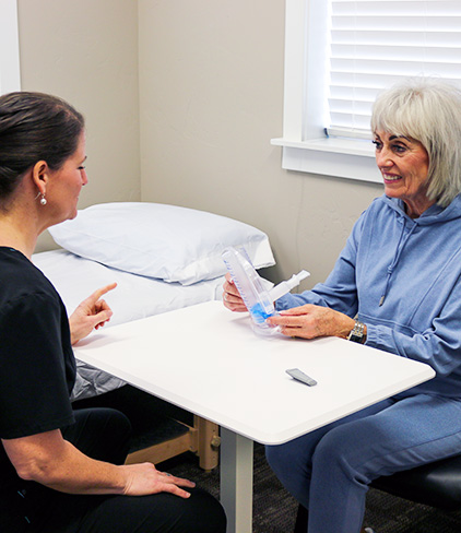 Physical therapist helping patient with pulmonary physical therapy
