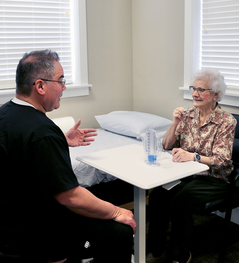 Physical therapist helping patient with pulmonary physical therapy